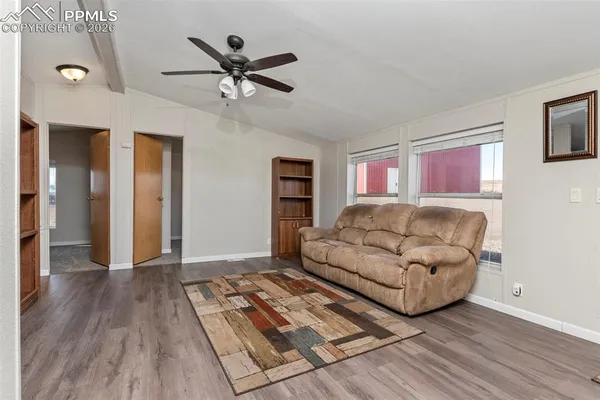 a living room with stainless steel appliances furniture and a kitchen view