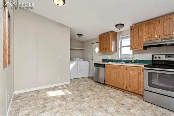 a kitchen with a refrigerator sink and cabinets