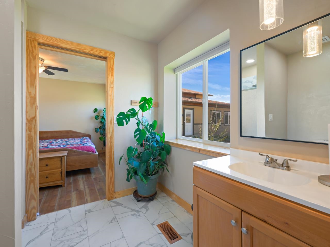 2209 Hatton Place Montrose, CO 81401 - Photo 21 of 42 a view of bathroom with a potted plant on a sink and a mirror