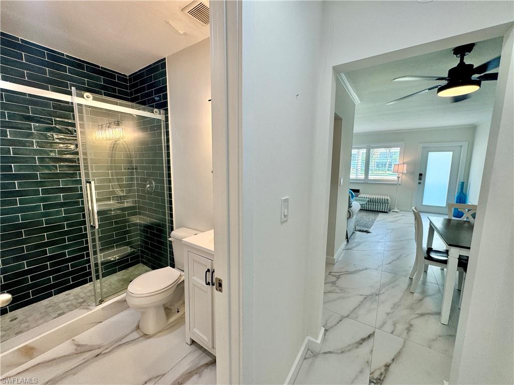 473 12th Avenue South, Unit B7 Naples, FL 34102 - Photo 15 of 21 Bathroom featuring ceiling fan, a shower with shower door, tile floors, toilet, and vanity