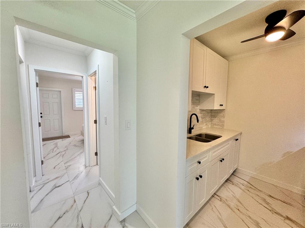 473 12th Avenue South, Unit B7 Naples, FL 34102 - Photo 16 of 21 Kitchen featuring ceiling fan, tasteful backsplash, light tile floors, sink, and white cabinetry