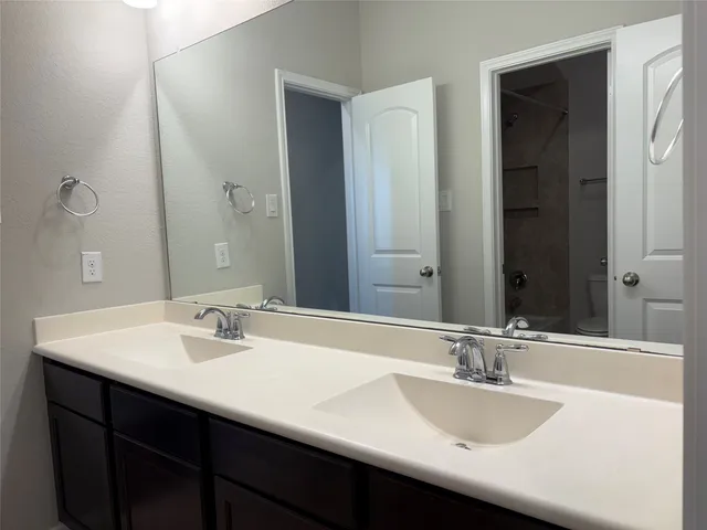 a bathroom with a double vanity sink and a mirror