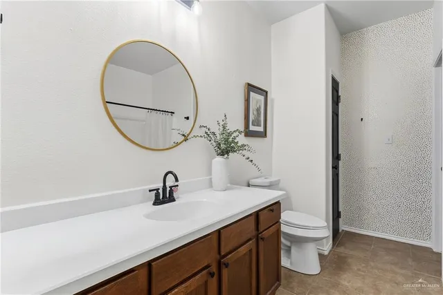 a bathroom with a sink a toilet and a mirror