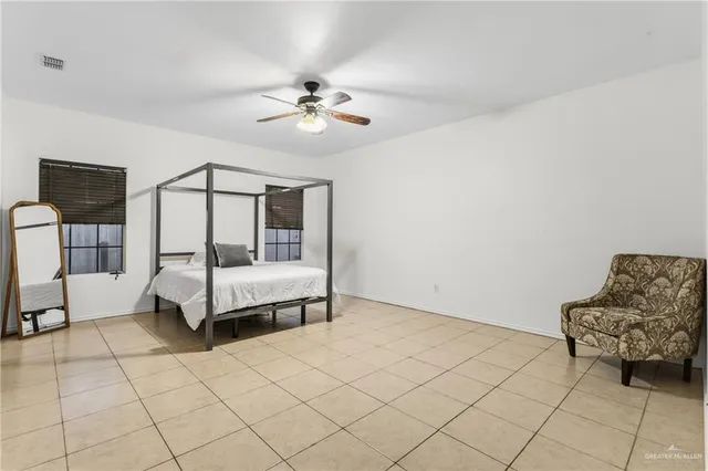 a spacious bedroom with a bed and a chandelier