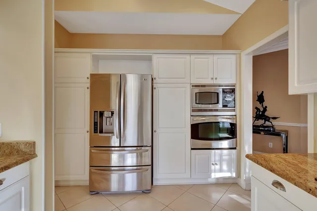 a living room with stainless steel appliances granite countertop furniture a rug a fireplace and a chandelier