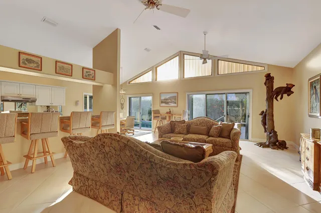 a living room with furniture a chandelier and a flat screen tv