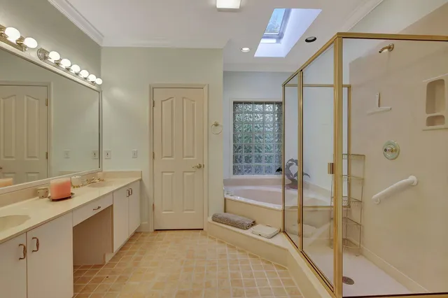 a bedroom with a bed couch chandelier windows and a rug