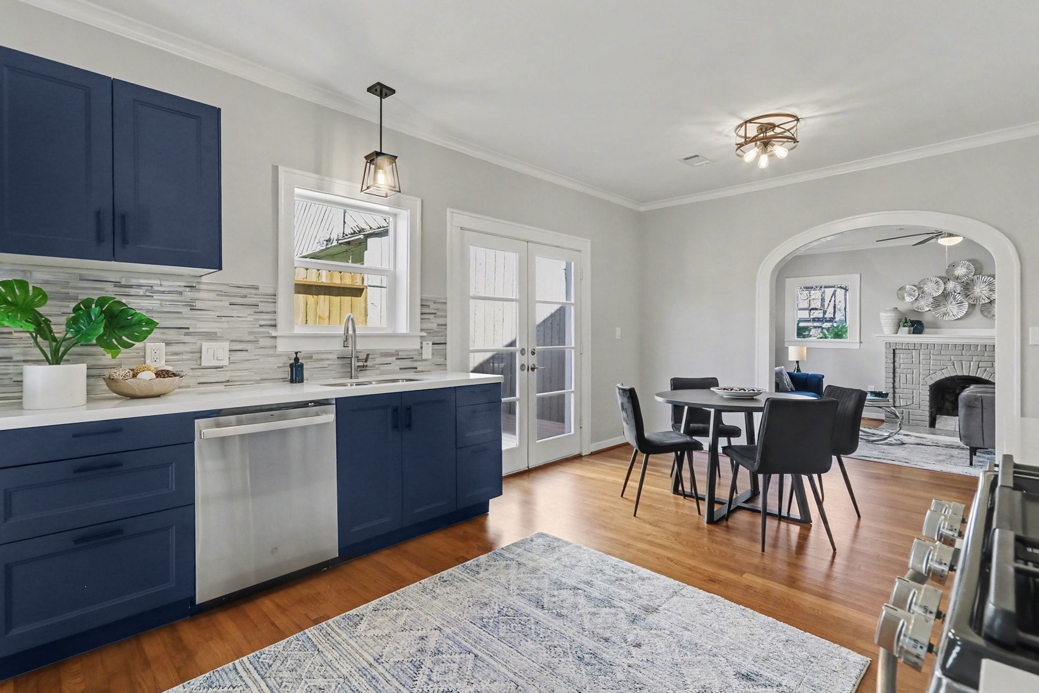 1901 Lexington Street Houston, TX 77098 - Photo 11 of 32 Experience modern elegance with these designer blue soft-close cabinets, Quartz countertops, and a striking glass tile backsplash, enhancing both the kitchen and utility room. All plumbing and lighting fixtures are new.