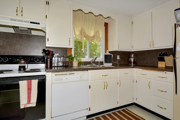 7-9 Sparkill Street Watertown, MA 02472 - Photo 14 of 27 a kitchen with granite countertop white cabinets and white appliances