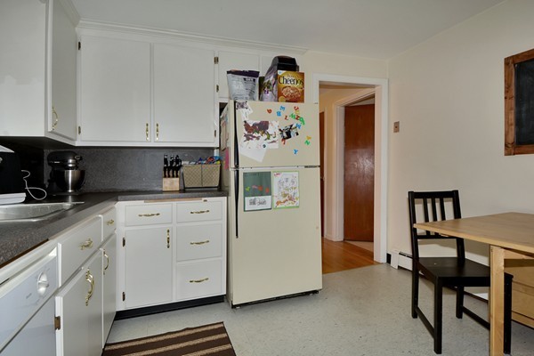 7-9 Sparkill Street Watertown, MA 02472 - Photo 15 of 27 a kitchen with white cabinets and refrigerator