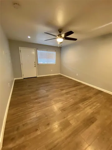 an empty room with a ceiling fan and window