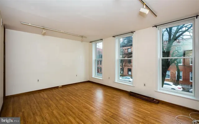 a view of a kitchen with refrigerator and wooden floor