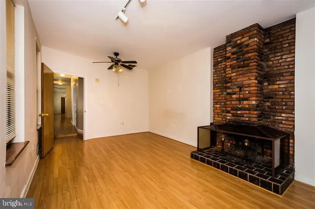 an empty room with wooden floor and a window