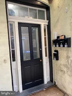 a view of an empty room with wooden floor and a bathroom