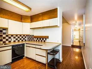 an empty room with wooden floor closet and windows