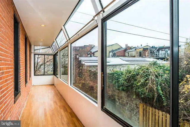 an empty room with wooden floor and a window