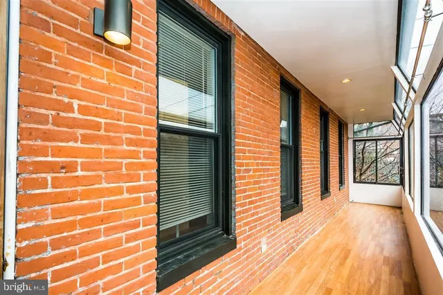 a view of an empty room with a ceiling fan and wooden floor