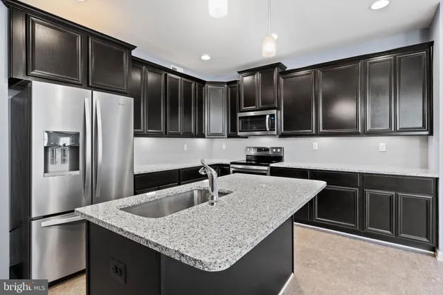 a kitchen with granite countertop stainless steel appliances and refrigerator
