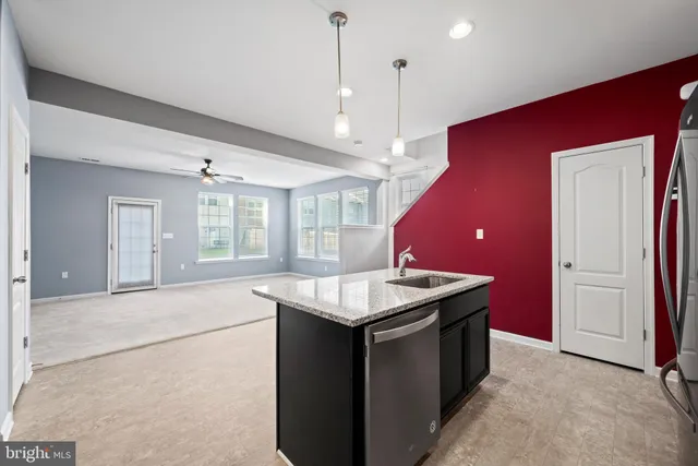 a kitchen with a stove center island a sink dishwasher with a dining table and chairs