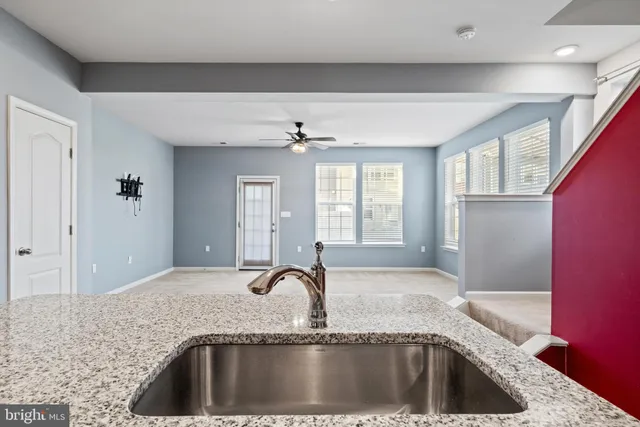 a kitchen with a sink granite counter tops and a large window