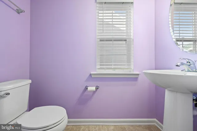 a bathroom with a sink a toilet and a window