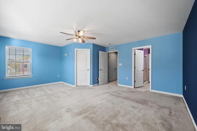 a view of an empty room with a ceiling fan