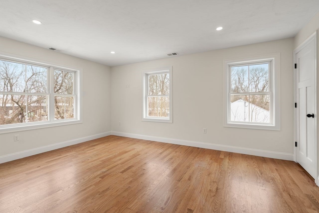 52 Freeman Street Avon, MA 02322 - Photo 13 of 17 a view of an empty room with wooden floor and a window