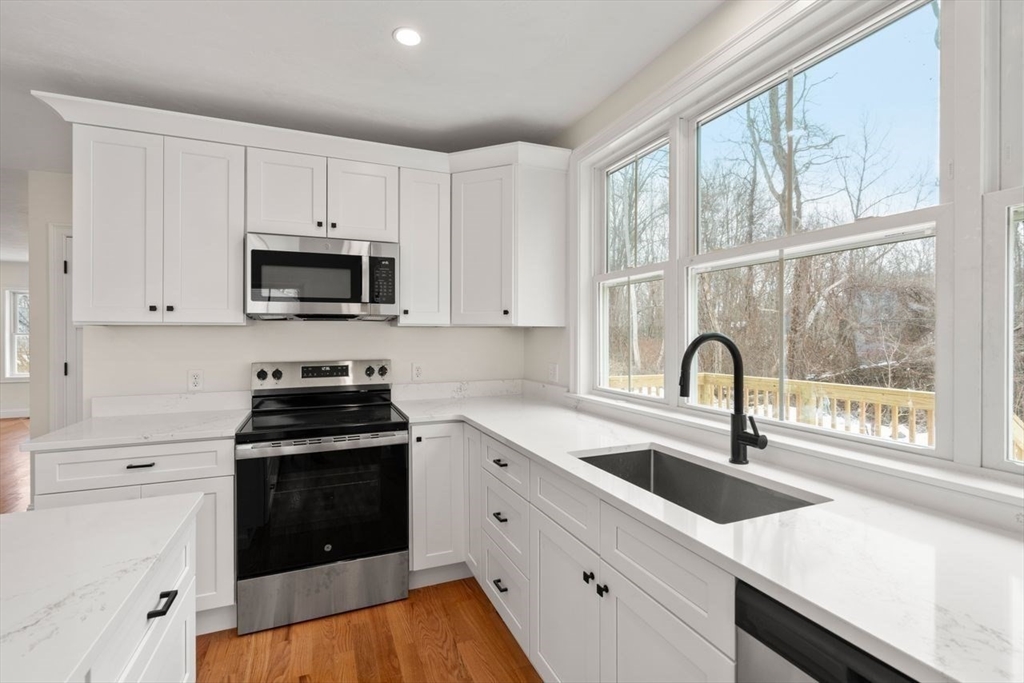 52 Freeman Street Avon, MA 02322 - Photo 2 of 17 a kitchen with a sink a stove and cabinets