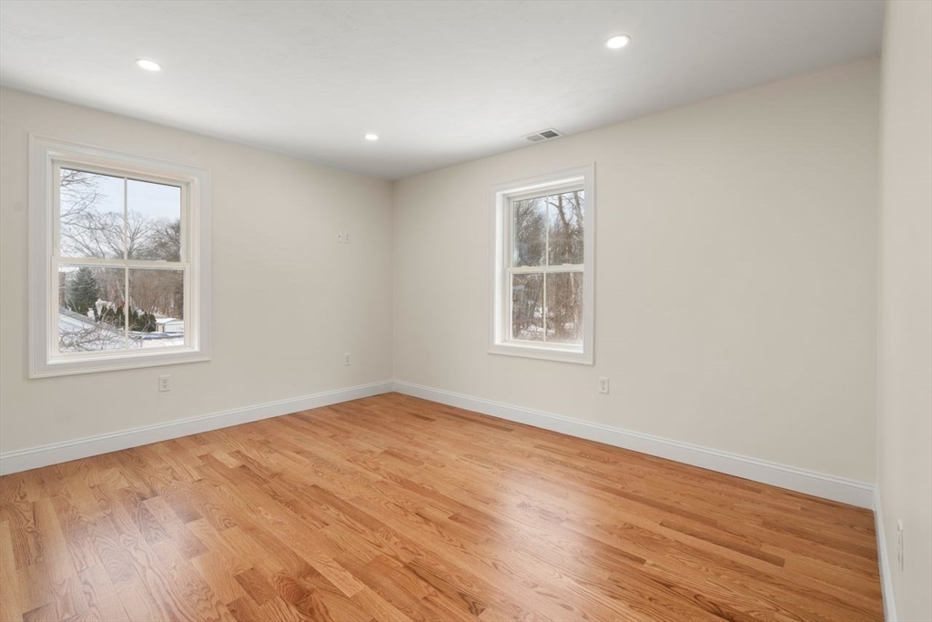 52 Freeman Street Avon, MA 02322 - Photo 7 of 17 a view of an empty room with wooden floor and a window