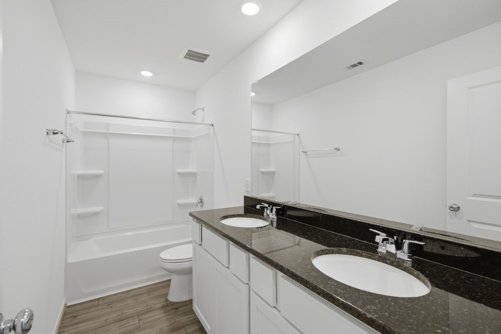 5607 Buttonbush Court Rosenberg, TX 77471 - Photo 22 of 37 a bathroom with a granite countertop sink toilet a large mirror and shower