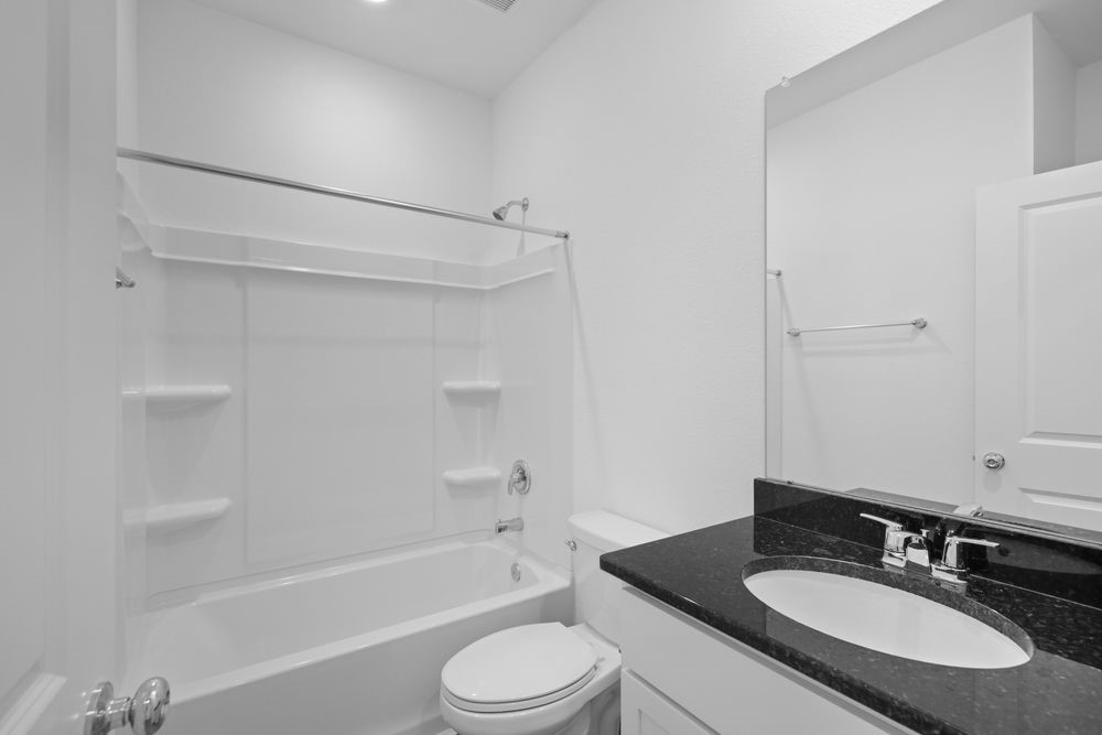 5607 Buttonbush Court Rosenberg, TX 77471 - Photo 10 of 37 a bathroom with a granite countertop sink toilet a mirror and shower