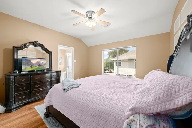 a bedroom with a bed and a flat tv screen on dresser