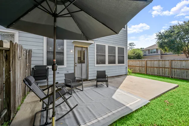 a view of a patio with table and chairs under an umbrella
