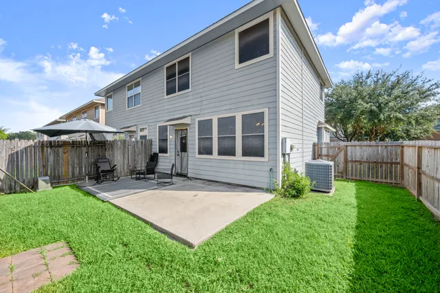 a view of an house with backyard and sitting area
