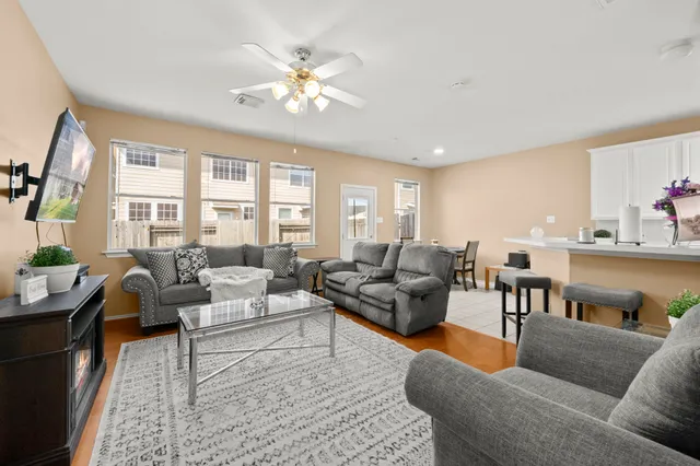a living room with furniture wooden floor and a large window