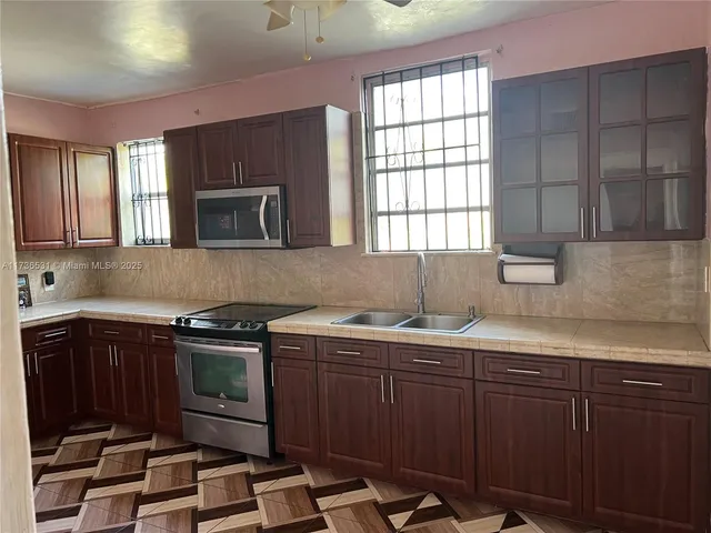 a kitchen with stainless steel appliances wooden cabinets and a stove top oven