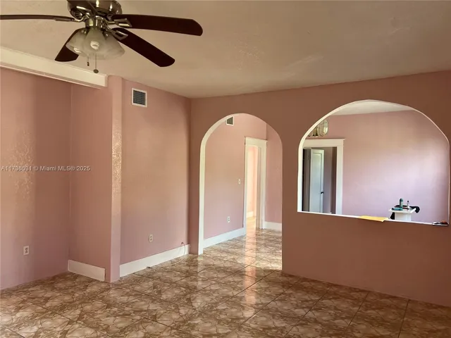 a view of a hallway with a chandelier fan and wooden floor