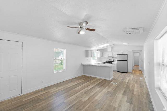 2600 North Hill Field Road, Unit 103A Layton, UT 84041 - Photo 7 of 31 Open-concept living space featuring wood-finish flooring, white walls, and a ceiling fan