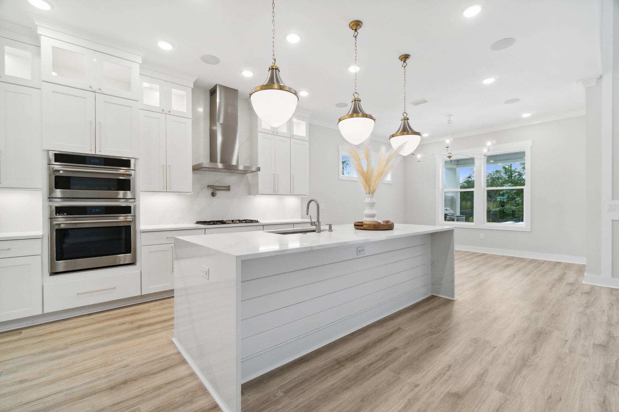 426 Lafayette Road Watersound, FL 32461 - Photo 22 of 78 a large white kitchen with a large island oven a stove white cabinetry and couches with wooden floor
