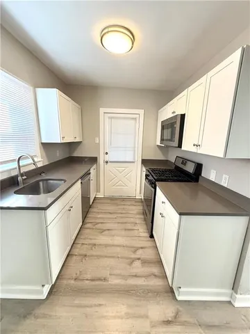 a kitchen with a stove a sink and a microwave