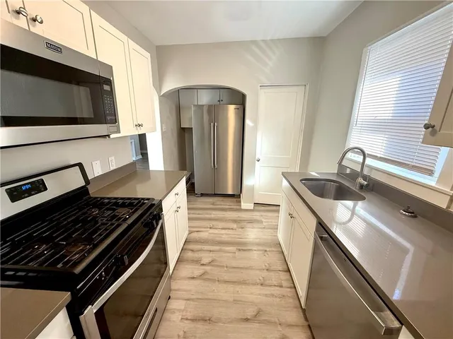 a kitchen with stainless steel appliances granite countertop a stove and a microwave