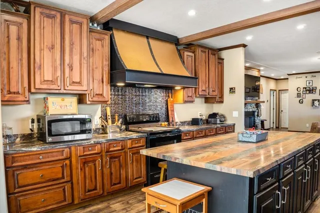 a kitchen with stainless steel appliances granite countertop a stove a sink and a microwave