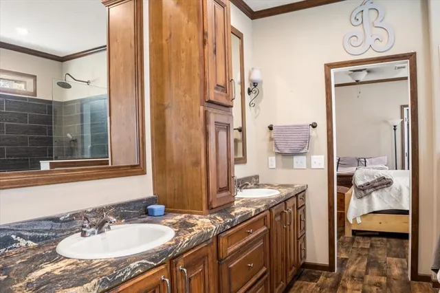 a bathroom with a granite countertop sink a mirror and a shower