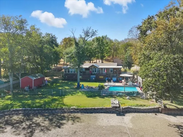 a view of a house with swimming pool and a yard