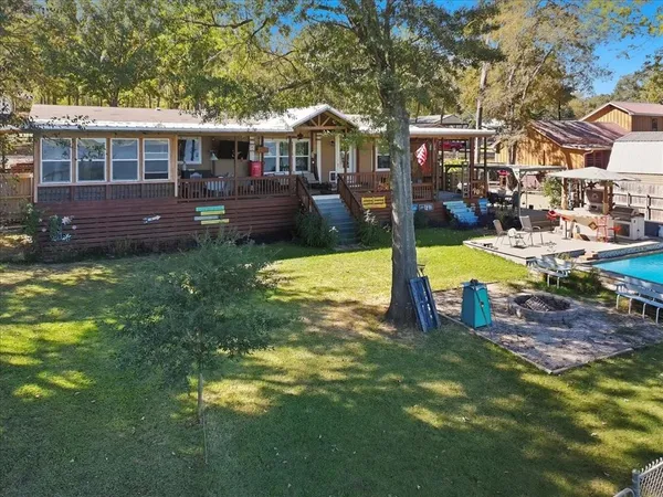 a view of a house with swimming pool and a yard