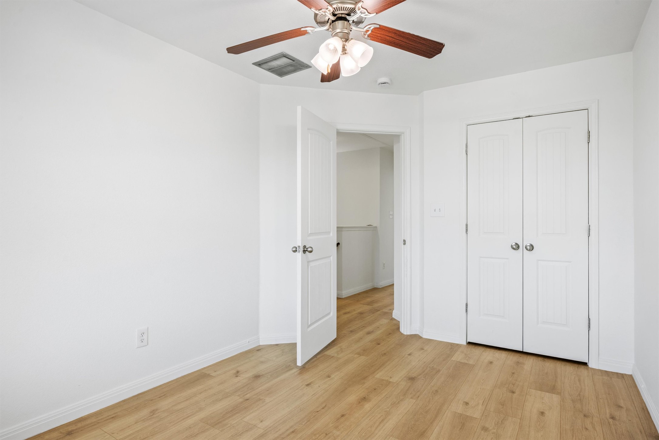 4516 Kind Way, Unit 253 Austin, TX 78725 - Photo 14 of 31 an empty room with wooden floor closet and ceiling fan