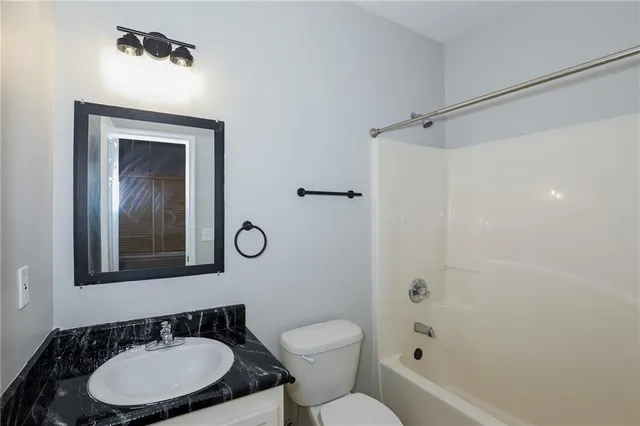 a bathroom with a toilet a sink and mirror