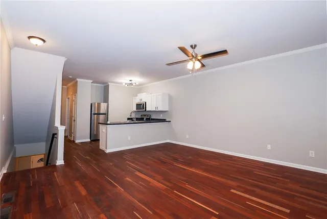 a living room with stainless steel appliances furniture a refrigerator and a fireplace