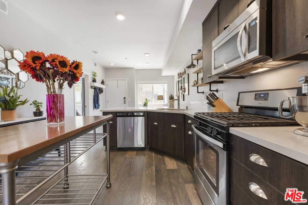 2972 Ripple Place, Unit 101 Los Angeles, CA 90039 - Photo 14 of 46 a kitchen with stainless steel appliances granite countertop a stove a sink dishwasher and a refrigerator with wooden floor