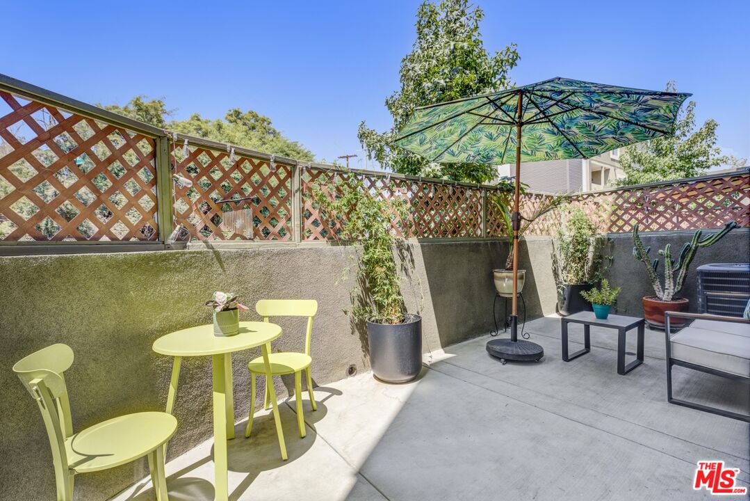 2972 Ripple Place, Unit 101 Los Angeles, CA 90039 - Photo 19 of 46 a patio with a table and chairs under an umbrella